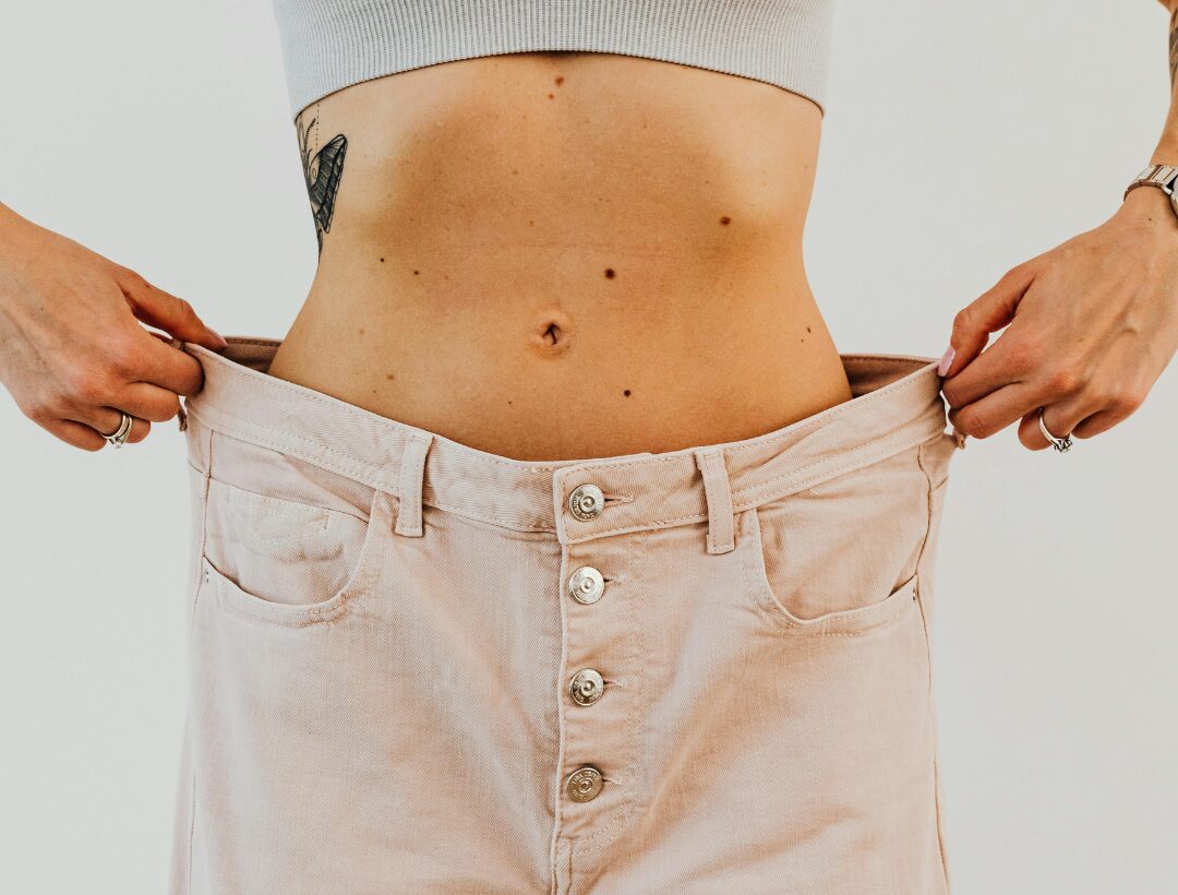 Close-up of woman's toned midsection measuring waist