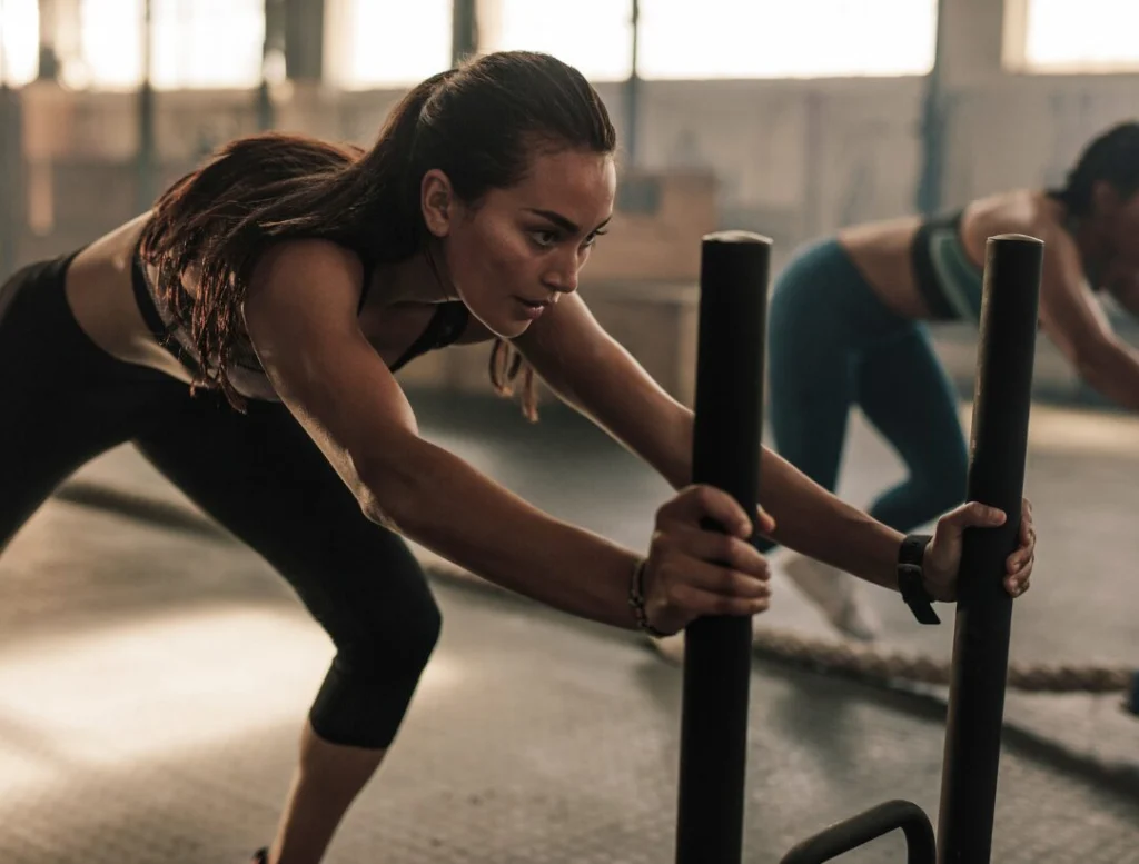 woman pushing sled strength training workout