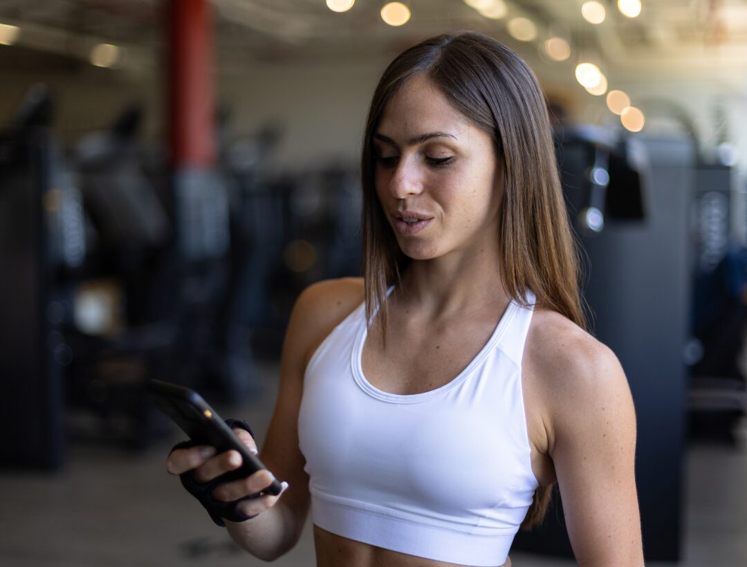 Fit woman in white sports bra standing confidently