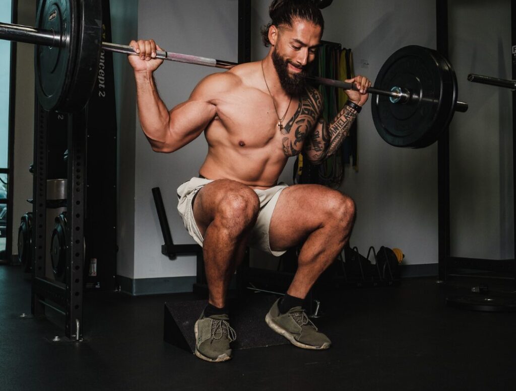 man performing barbell squat exercise