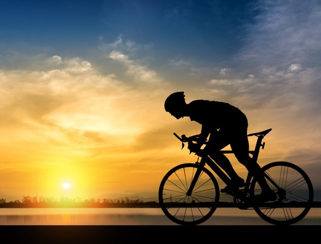 cyclist riding bike sunset cardio workout