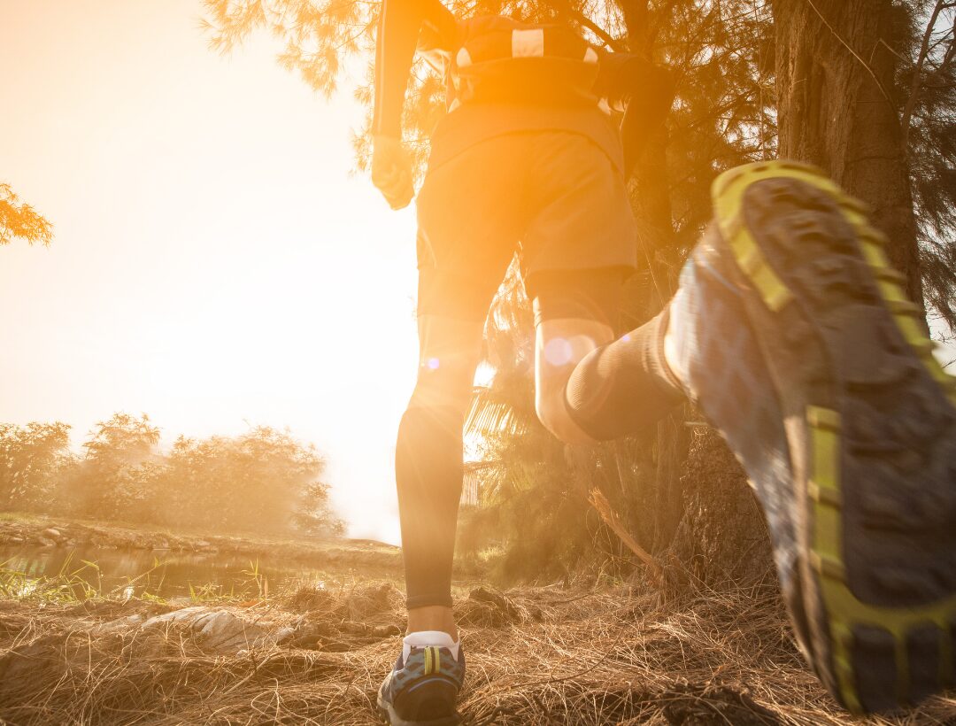Runner silhouetted against golden sunset outdoors