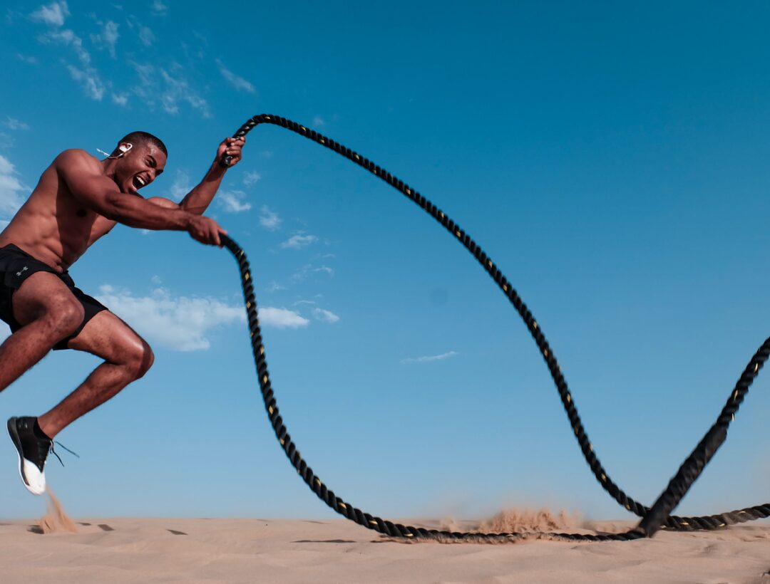 Athlete doing battle ropes workout outdoors