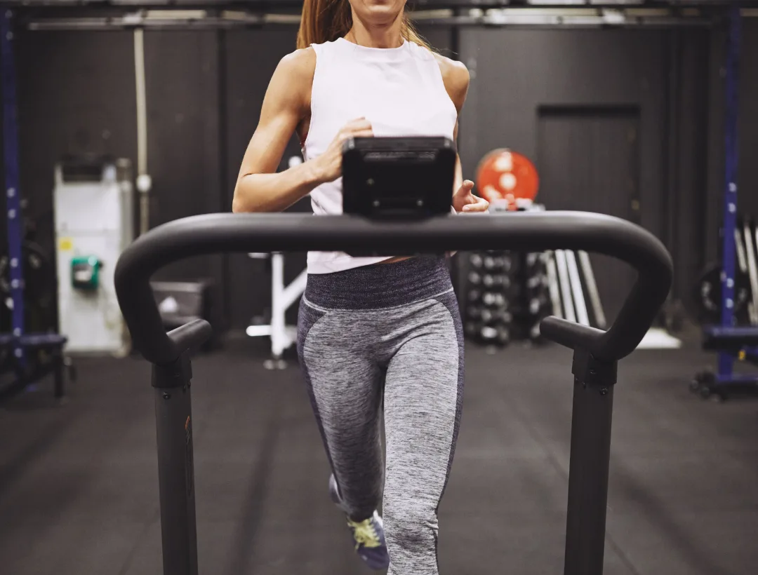 woman running on a curved treadmill